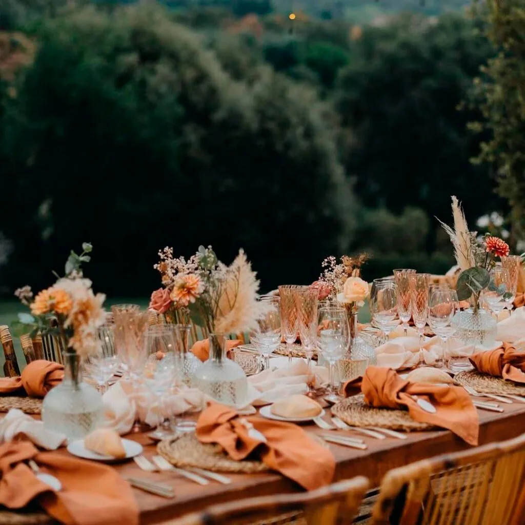 Torre Sever outdoor banquet space with long shared tables set among the trees and lights, the venue's Mediterranean dinner setting